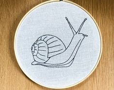 a small embroidery project with a snail on it