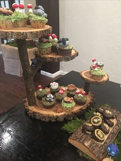 there are cupcakes that are on the tree slices and in the middle is moss