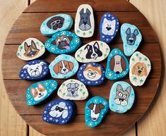 decorated rocks with dogs on them sitting on a wooden table in the shape of hearts