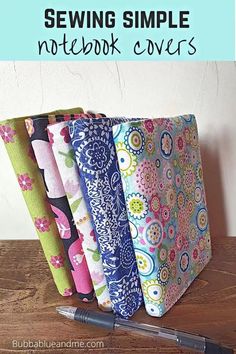 four different types of notebook covers sitting on top of a wooden table