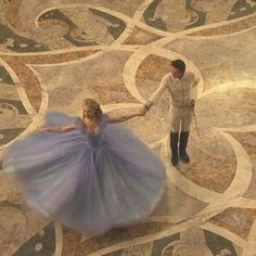 a woman in a blue dress is dancing with a man wearing a white jacket and tie