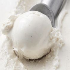 a scoop of ice cream sitting on top of a white counter next to a spoon