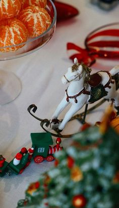 a white horse pulling a sleigh filled with oranges on top of a table