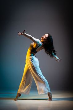 a woman in yellow and white is dancing