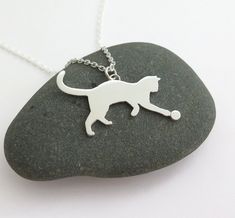 Sterling silver cat necklace. This cute cat will make a special gift for cat lovers! A cat playing with a ball, hand sawn from sterling silver. One of 4 new cats pendants in my shop (you can see the other cats pendants in the last photo). Pendant size: 2.3 cm wide, 1.5 cm high (not including the tail). 1 by 0.6 inch. Chain length: 45 cm/ 18 inches. Please write me if you want the chain at any other length. More cats necklaces here: https://www.etsy.com/listing/495106709/cat-pendant-necklace-sitt Silver Cat Pendant, Cat Necklace Silver, Necklace Cat, Cat Pendant Necklace, Cat Lady Gift, Cat Earrings Studs, Cat Pendant, Sterling Silver Cat, Silver Cat