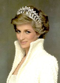 a woman wearing a tiara and smiling at the camera with snowflakes around her