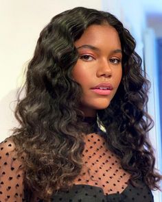 a close up of a person wearing a dress and long curly hair with polka dots on it