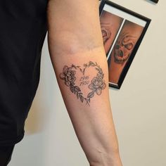 a woman's arm with a skull and flowers tattoo on the left side of her arm