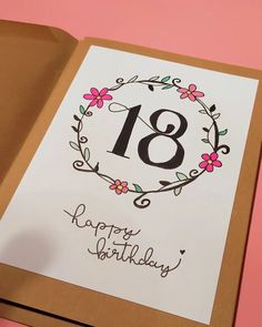 an open birthday card with the number eighteen printed on it and flowers in a wreath