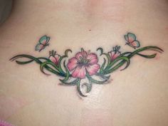 a woman's back with pink flowers and butterflies on her neck, tattoo design