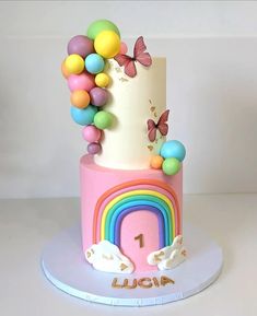 a birthday cake decorated with rainbows and butterflies