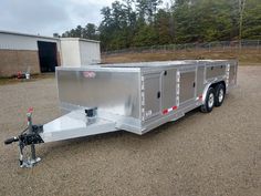 a silver trailer parked in a gravel lot