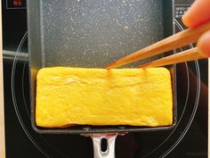 someone using chopsticks to stir food in a pan