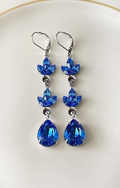 "Pair of long earrings featuring Swarovski crystals in sapphire blue.  2 7/8\" long. Thanks for stopping by!" Luxury Blue Chandbali Danglers, Blue Sterling Silver Chandelier Earrings For Wedding, Blue Crystal Teardrop Bridal Earrings, Blue Crystal Teardrop Dangle Earrings, Blue Crystal Teardrop Earrings, Blue Teardrop Chandelier Earrings For Formal Occasions, Formal Blue Teardrop Chandelier Earrings, Blue Long Drop Jewelry For Wedding, Blue Long Drop Wedding Jewelry