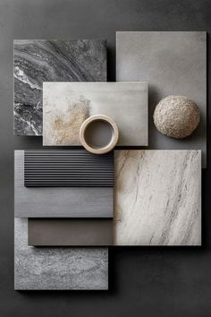 an assortment of different types of marbles and tiles on a black surface with a white vase