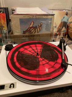 an old record player is sitting on top of a table next to other records and cds