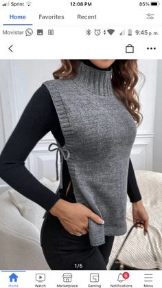 a woman in black pants and grey sweater posing with her hand on her hip bag