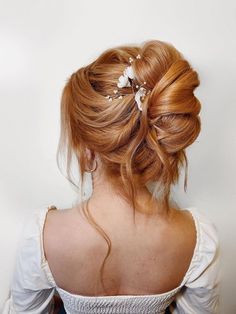 a woman with red hair is wearing a white dress and has flowers in her hair