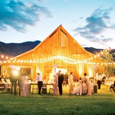 an outdoor wedding reception with string lights