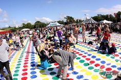 a large group of people standing on top of a colorful floor covered in polka dots