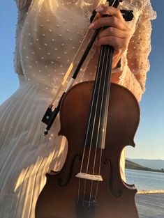 a woman in white dress holding a violin