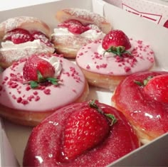 strawberry donuts with icing and sprinkles in a box