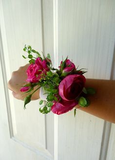 a bouquet of pink roses is held on the arm of a woman's hand