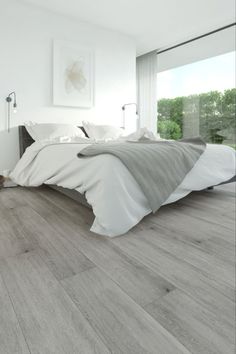 a large bed sitting on top of a hard wood floor next to a white wall