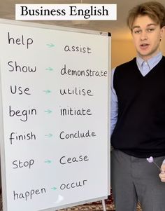 a man standing next to a white board with writing on it