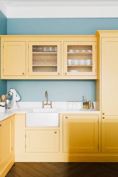 a kitchen with yellow cabinets and blue walls