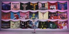 there is a woman standing in front of a display of t - shirts on the wall