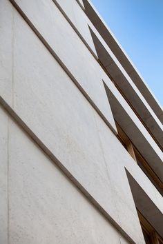 the side of a building that is made out of concrete and has windows on each side