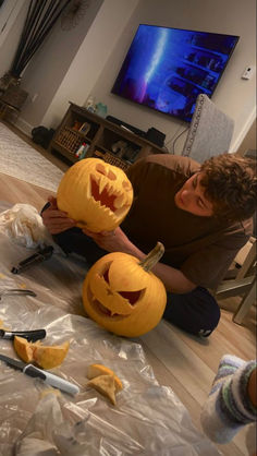 a man is carving pumpkins for halloween