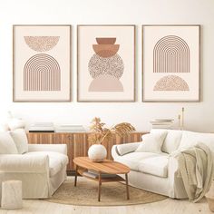 three paintings hang on the wall above a couch and coffee table in a living room