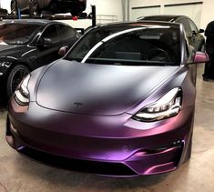 two tesla cars are parked in a garage