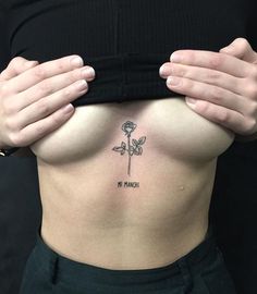 a woman's stomach with a flower tattoo on it