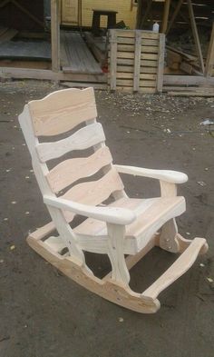 a white wooden rocking chair sitting on the ground