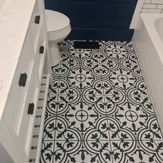 a white toilet sitting next to a bath tub in a bathroom on top of a tiled floor