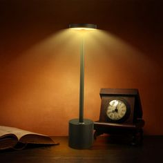 a lamp that is on top of a table next to a book and an open book