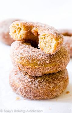 three donuts stacked on top of each other with one bite taken out of them