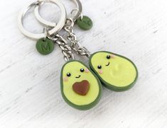 two slices of avocado with faces on them are hanging from a keychain