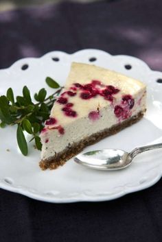 a piece of cheesecake on a plate with a fork and leafy garnish