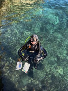 a man in a diving suit and snorkels floating on clear blue water