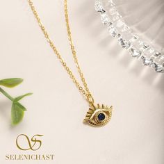 Eye-catching and elegant. A unique gold chain necklace with an amazing celestial gold pendant featuring evil eye with clear lashes. Have sapphire blue CZ set into the evil eye charm, it dazzles in the lights, accentuating the beauty of your skin and making you sparkly at any parities. Spiritual Gold Eye-shaped Necklace, Elegant Cubic Zirconia Evil Eye Necklaces, Elegant Cubic Zirconia Evil Eye Necklace, Elegant Evil Eye Necklace With Cubic Zirconia, Elegant Yellow Gold Eye-shaped Necklace, Gold Eye Necklace With Diamond Eyes, Gold Dangle Jewelry With Evil Eye, Party Yellow Gold Pendant Charm Necklaces, Party Yellow Gold Pendant Charm Necklace