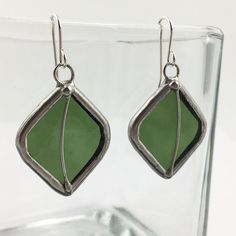 "Opaque, olive green stained glass earring pair edged in silver, accented with silver wire. The simple French hook ear wires are sterling silver.  Total Size: 1 15/16\" x 7/8\" each Each item by Faerie Glass is 100% uniquely hand-crafted with quality materials that are lead-free. NOTE - All photographs are taken in effort to best represent the product. Color of actual jewelry may vary slightly from photographs." Nickel-free Silver Earrings With Recycled Glass, Nickel-free Silver Earrings In Recycled Glass, Stained Glass Earrings, Nugget Necklace, Olive Leaf, Glass Rings, Glass Earrings, Leaf Shapes, Beautiful Gift Boxes