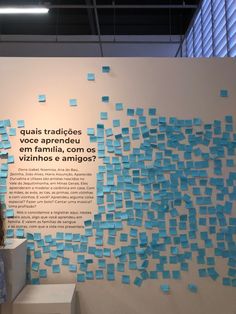 a woman standing in front of a wall covered with blue and white post it notes