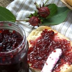 there is a jar of jam next to some bread