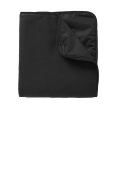 a black blanket folded on top of a white wall