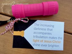 a piece of paper with a pink flashlight attached to it on top of a wooden table