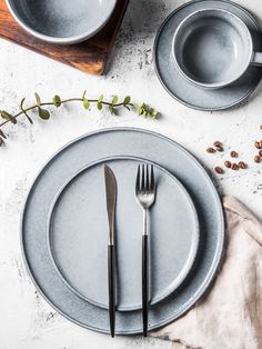 a table setting with silverware and flowers on it, including two forks and spoons